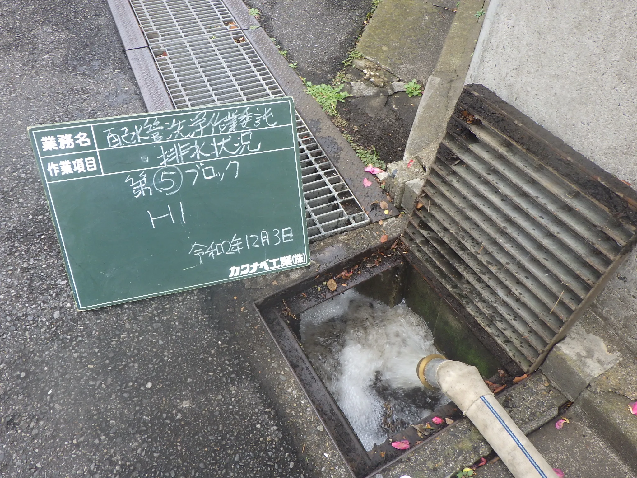 管から白く濁った水が側溝へ排出されている現場写真