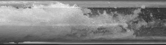 透明な管の内部を撮影した写真。水のかたまり（水塊）が管内を進み、そのうしろで水が白く泡立ちながら旋回している